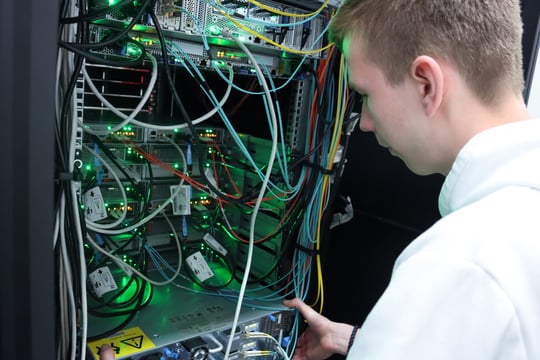 Technische Informatik - Student steht vor einem Schaltschrank