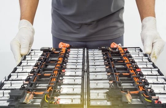 Hands in gloves of technology experts Electric car, EV car opening a lithium-ion car battery 