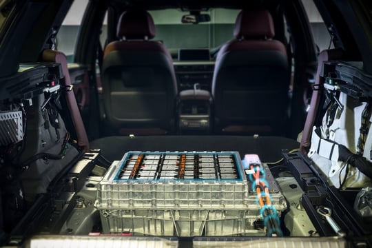 Electric car lithium battery pack and power connections on EV car background.