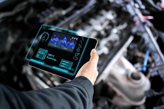 Car mechanic who checks the ECU electronic control unit with a wireless OBD or OBD2 scanner