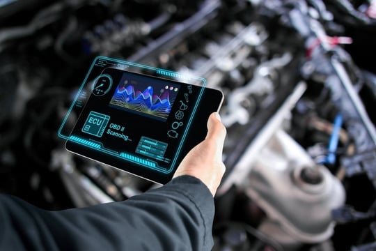 Car mechanic who checks the ECU electronic control unit with a wireless OBD or OBD2 scanner
