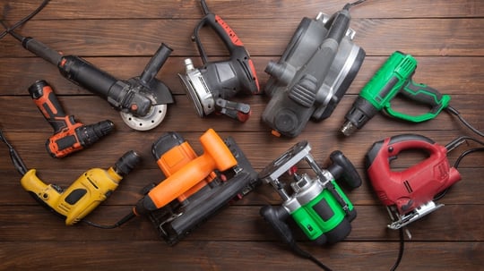 Various power tools arranged on a brown table