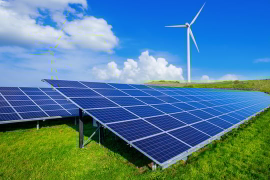 Solar cells and wind turbine against a blue sky